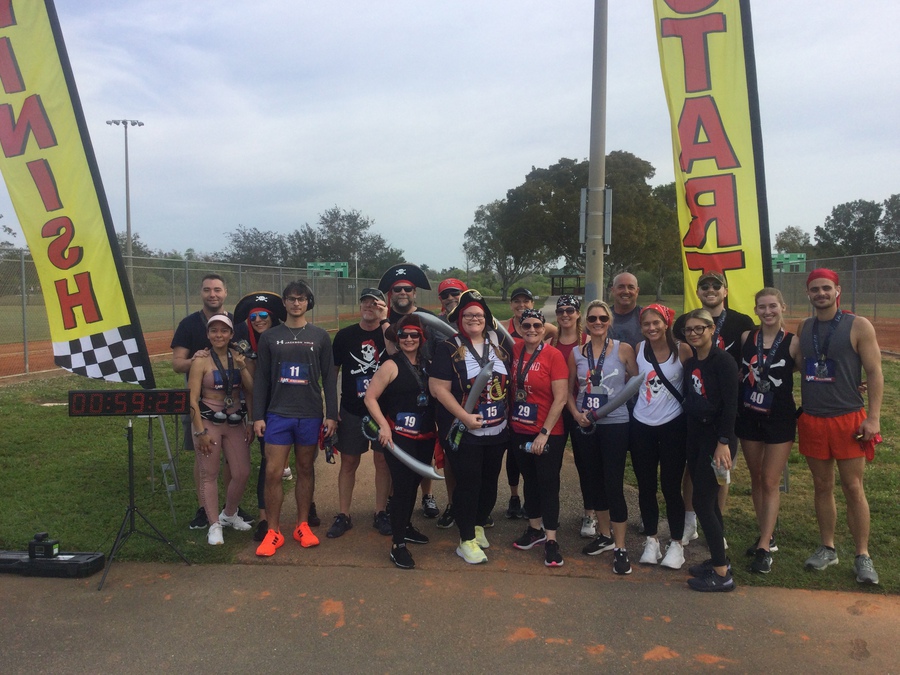 US Road Running participants gathering beneath a finish arch