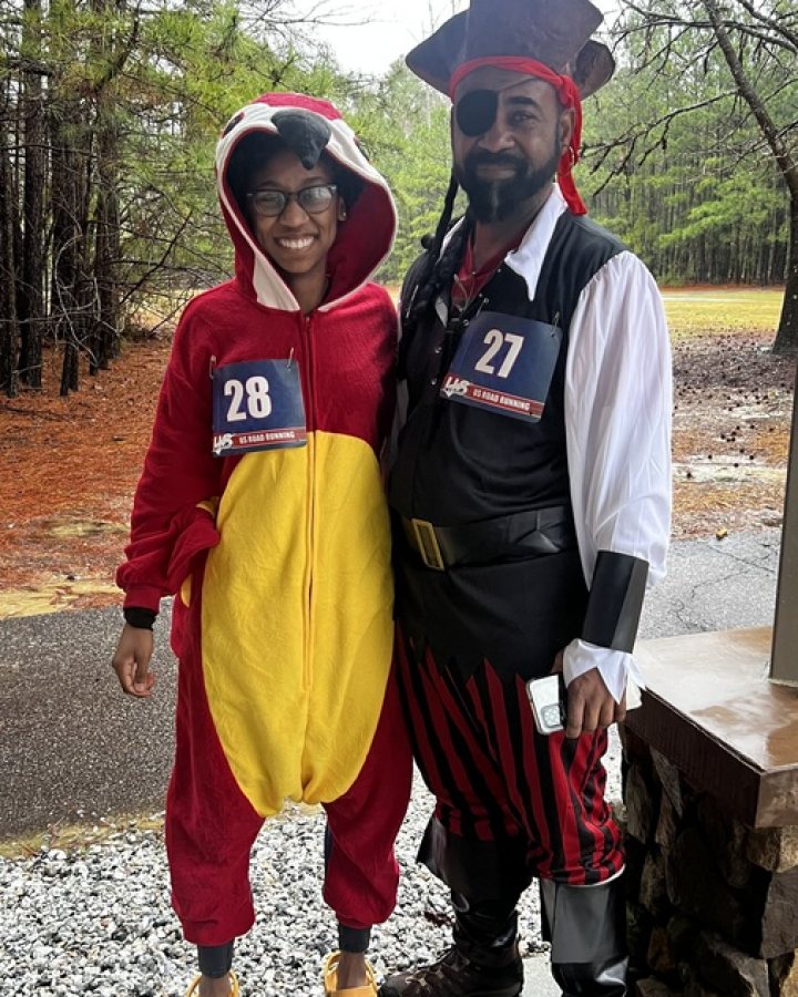 US Road Running race day photo with runners, walkers, finisher medals, and race staff