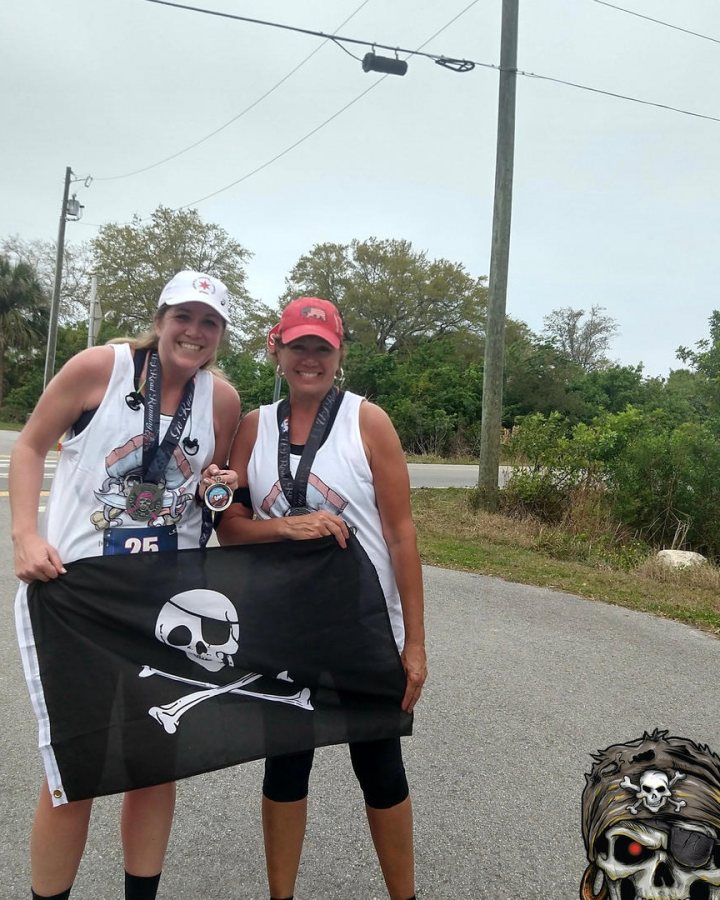 US Road Running race day photo with runners, walkers, finisher medals, and race staff