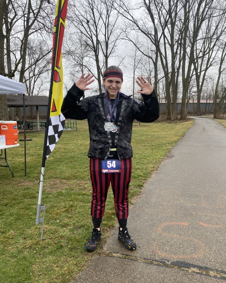 US Road Running race day photo with runners, walkers, finisher medals, and race staff
