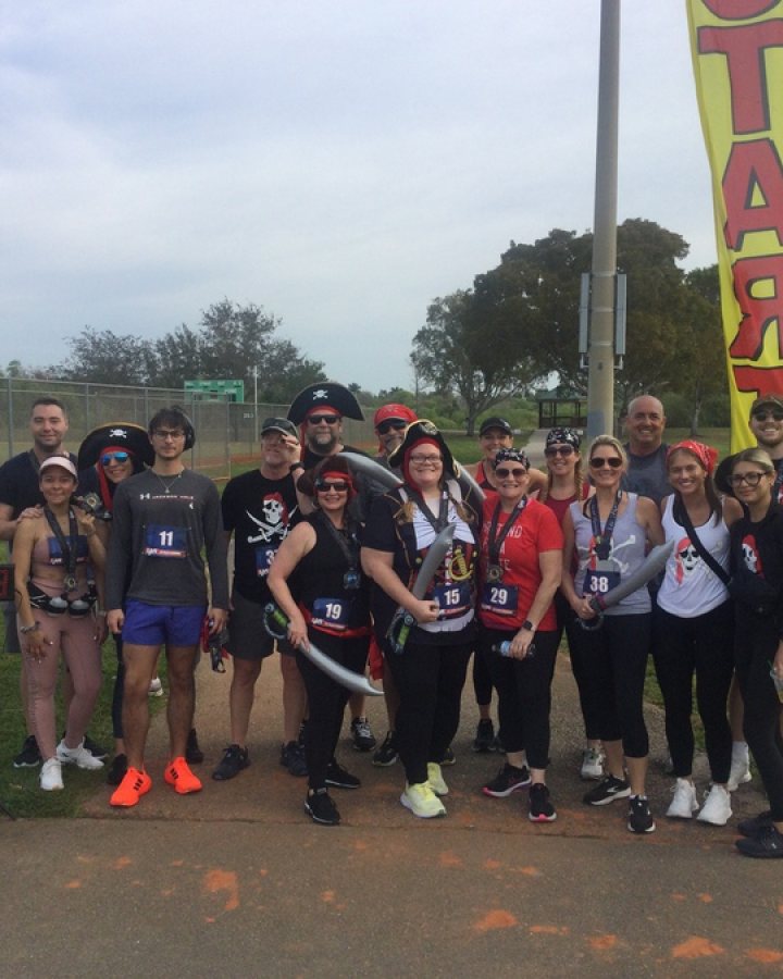 US Road Running race day photo with runners, walkers, finisher medals, and race staff