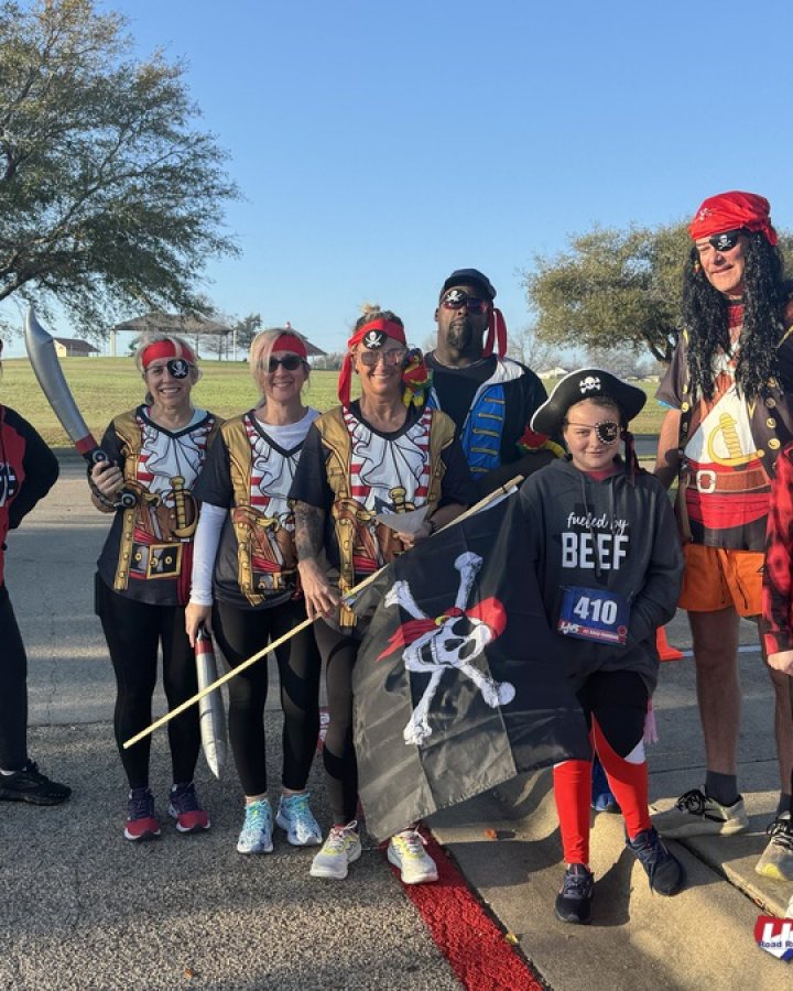 US Road Running race day photo with runners, walkers, finisher medals, and race staff
