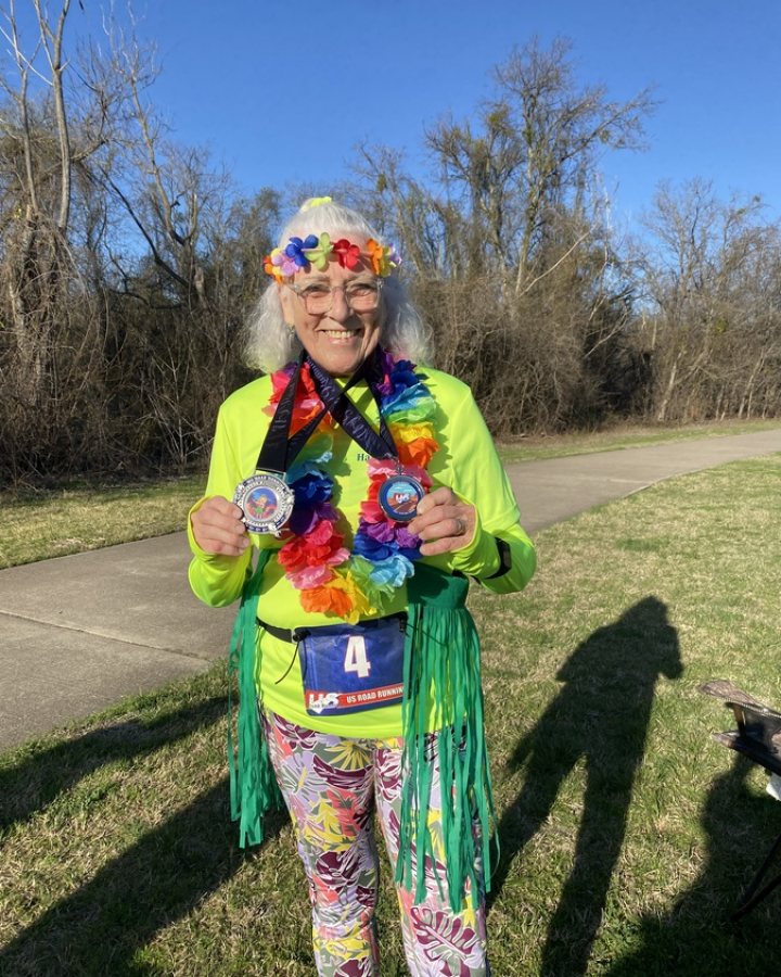 US Road Running race day photo with runners, walkers, finisher medals, and race staff