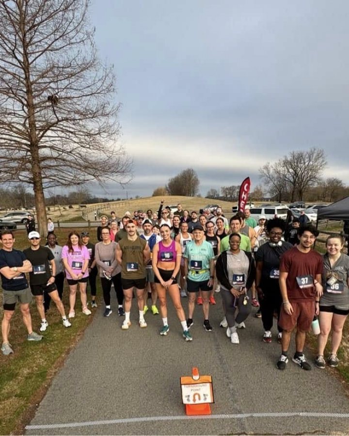 US Road Running race day photo with runners, walkers, finisher medals, and race staff