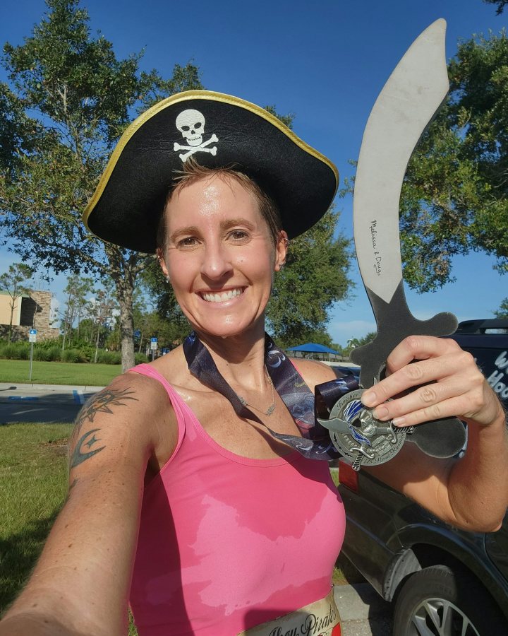 US Road Running race day photo with runners, walkers, finisher medals, and race staff