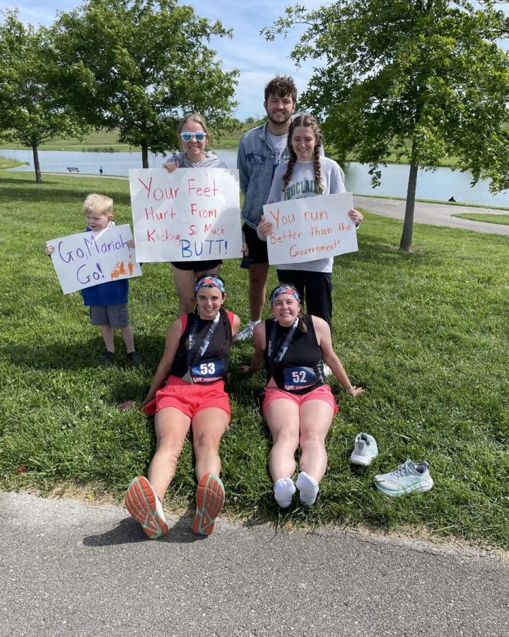 US Road Running race day photo with runners, walkers, finisher medals, and race staff