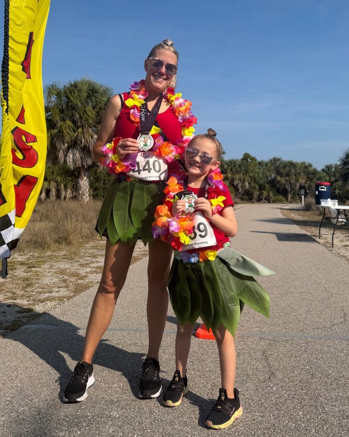 US Road Running race day photo with runners, walkers, finisher medals, and race staff