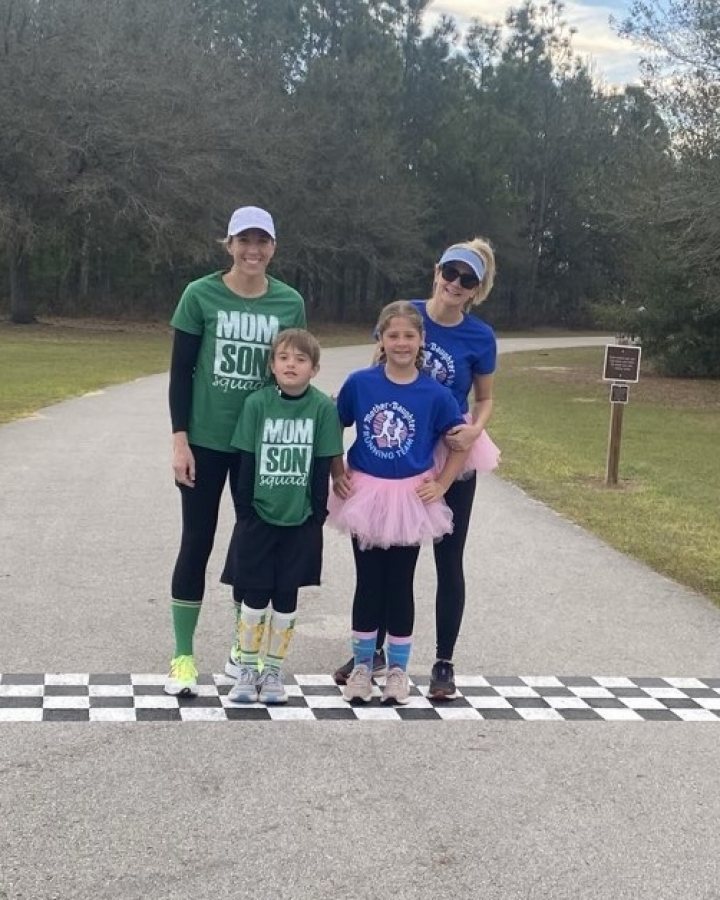 US Road Running race day photo with runners, walkers, finisher medals, and race staff