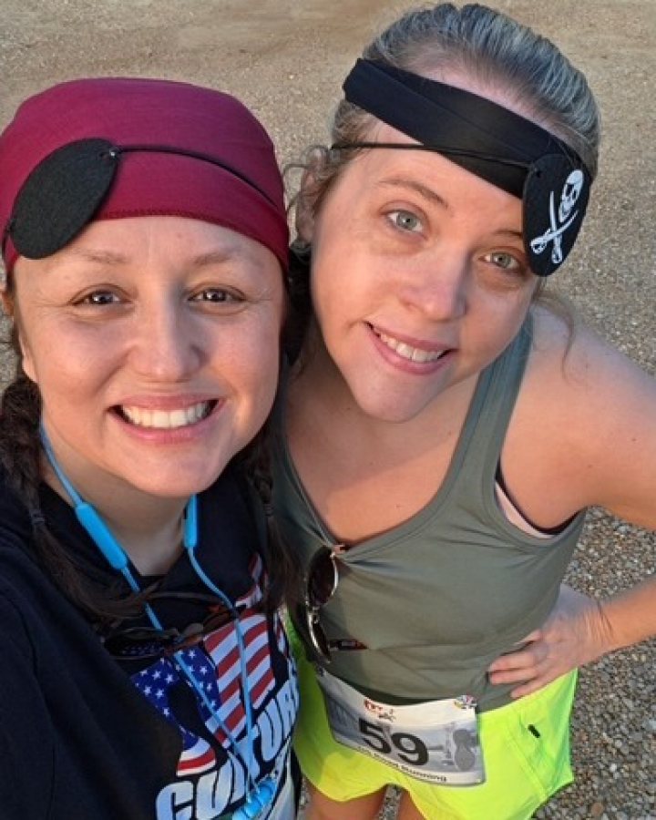 US Road Running race day photo with runners, walkers, finisher medals, and race staff