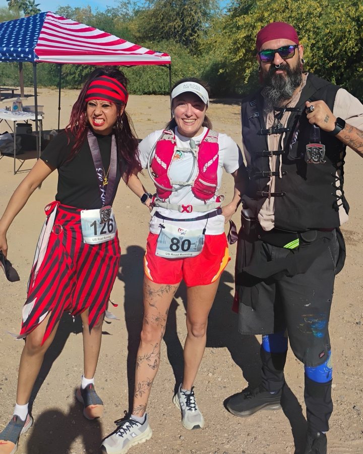 US Road Running race day photo with runners, walkers, finisher medals, and race staff