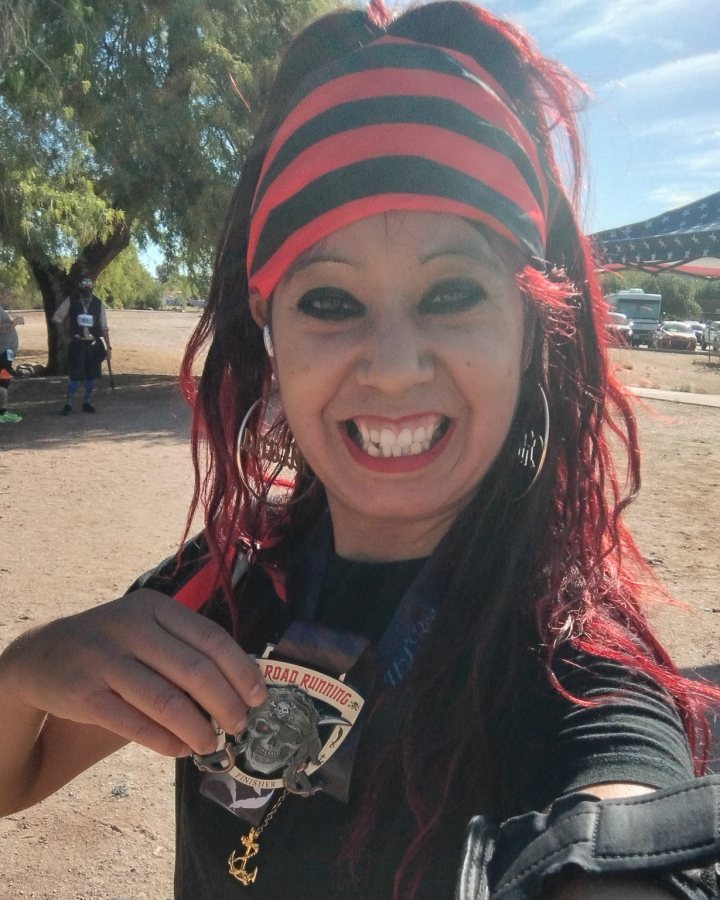 US Road Running race day photo with runners, walkers, finisher medals, and race staff