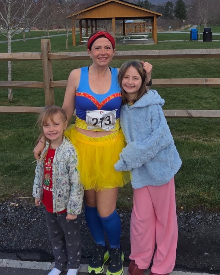 US Road Running race day photo with runners, walkers, finisher medals, and race staff