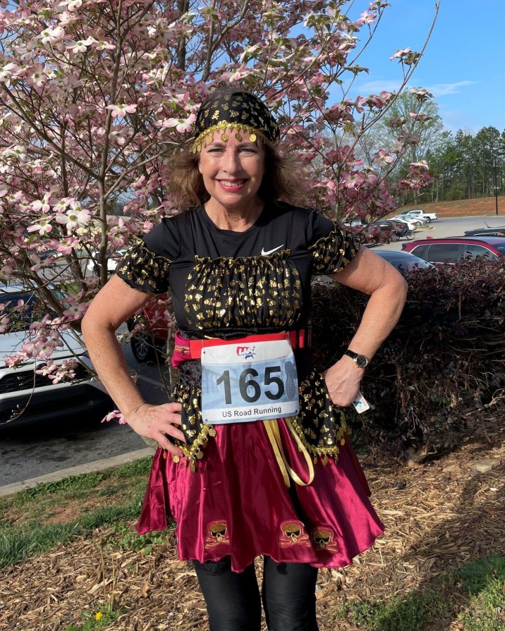 US Road Running race day photo with runners, walkers, finisher medals, and race staff
